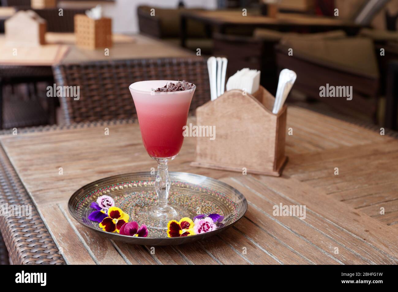 Roter Cocktail mit Schaum und Schokoladenrasur auf dem Restauranttisch Stockfoto