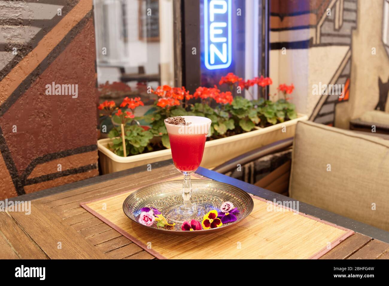 Roter Cocktail mit Schaum und Schokoladenrasur auf dem Restauranttisch Stockfoto