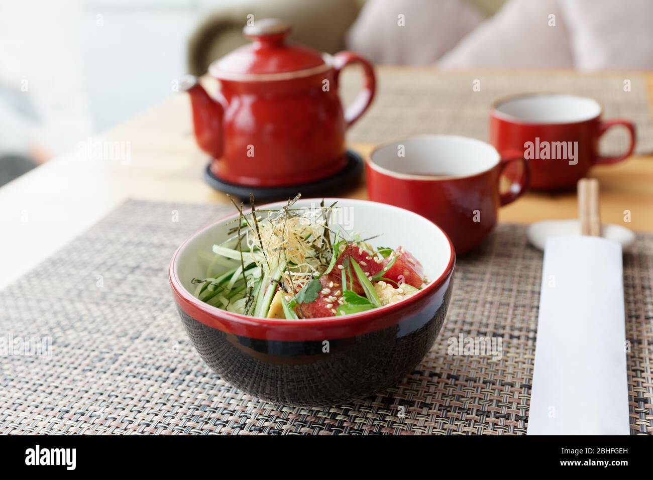 Poke Schüssel mit rohem Thunfisch, Avocado und Algen auf asiatischen Restaurant Tisch Stockfoto