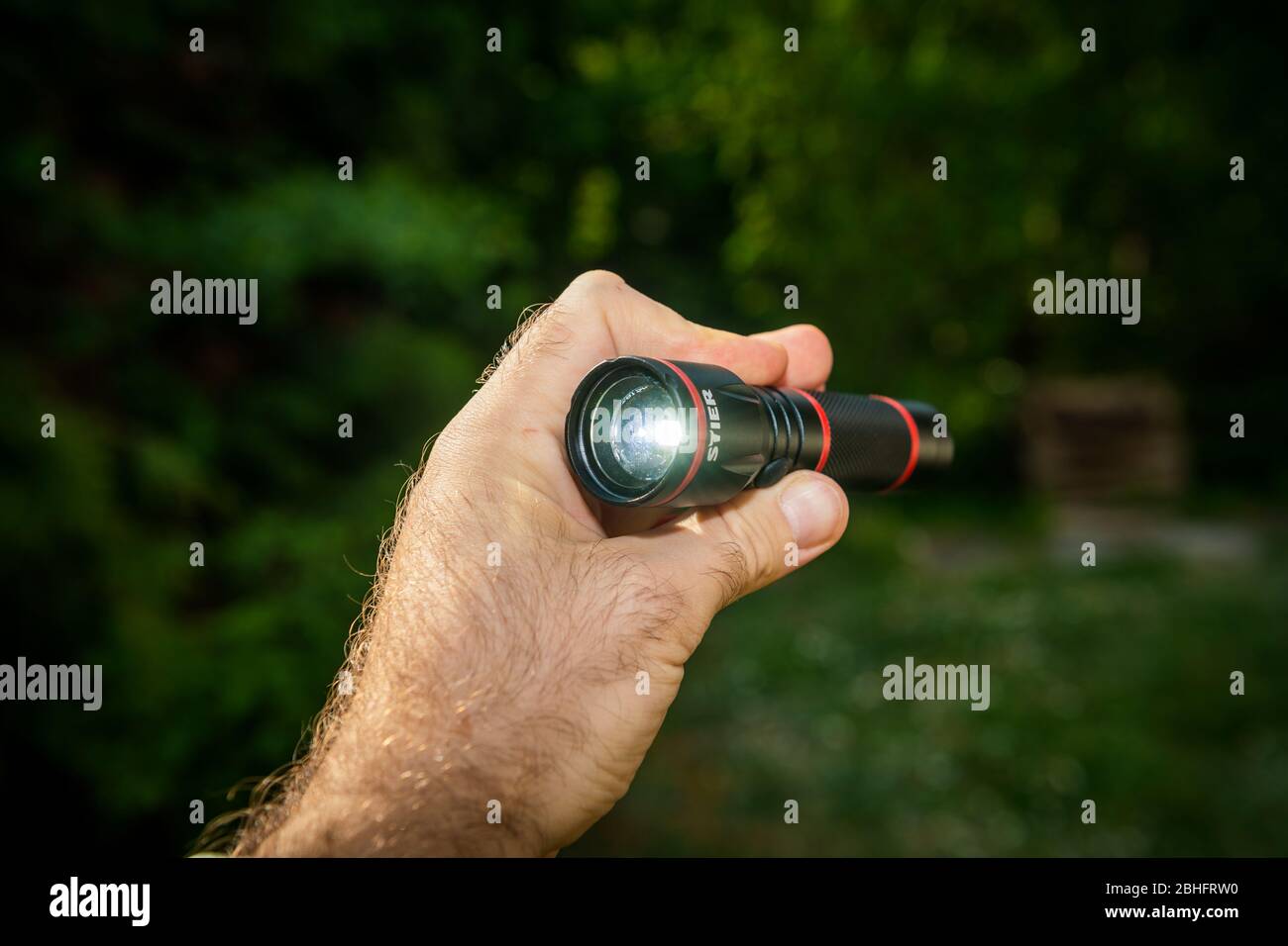 Paris, Frankreich - 24. Apr 2020: Männliche Hand hält neue Mini-LED Stier  Taschenlampe Taschenlampe grün Wald Hintergrund - STIER Werkzeuge ist ein  deutscher Werkzeughersteller Stockfotografie - Alamy