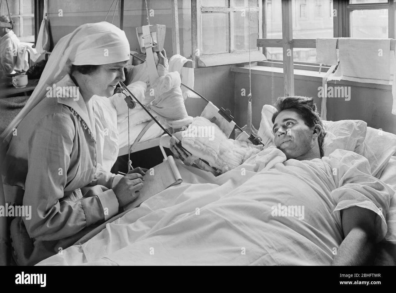 Arbeiter des amerikanischen Roten Kreuzes schreiben einen Brief für einen amerikanischen Soldaten, dessen rechter Arm behindert ist, Base Hospital 41, Saint Denis, Frankreich, Lewis Wickes Hine, amerikanische Nationale Rotkreuz-Fotolabor-Sammlung, September 1918 Stockfoto