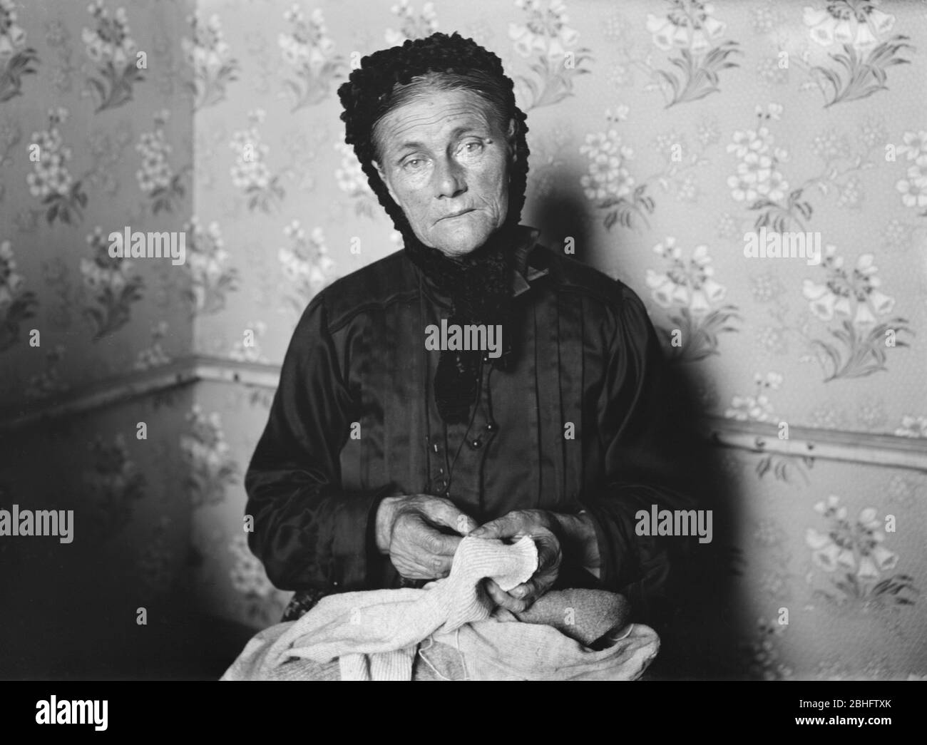 Flüchtlingsfrau, die beim amerikanischen Roten Kreuz angestellt ist, um Socken für amerikanische Soldaten zu flicken, die Teil der Bergungsarbeit sind, die Frauen zur Selbsthilfe befähigt, Tours, Frankreich, Lewis Wickes Hine, amerikanische Nationale Rotkreuz-Fotokollektion, September 1918 Stockfoto