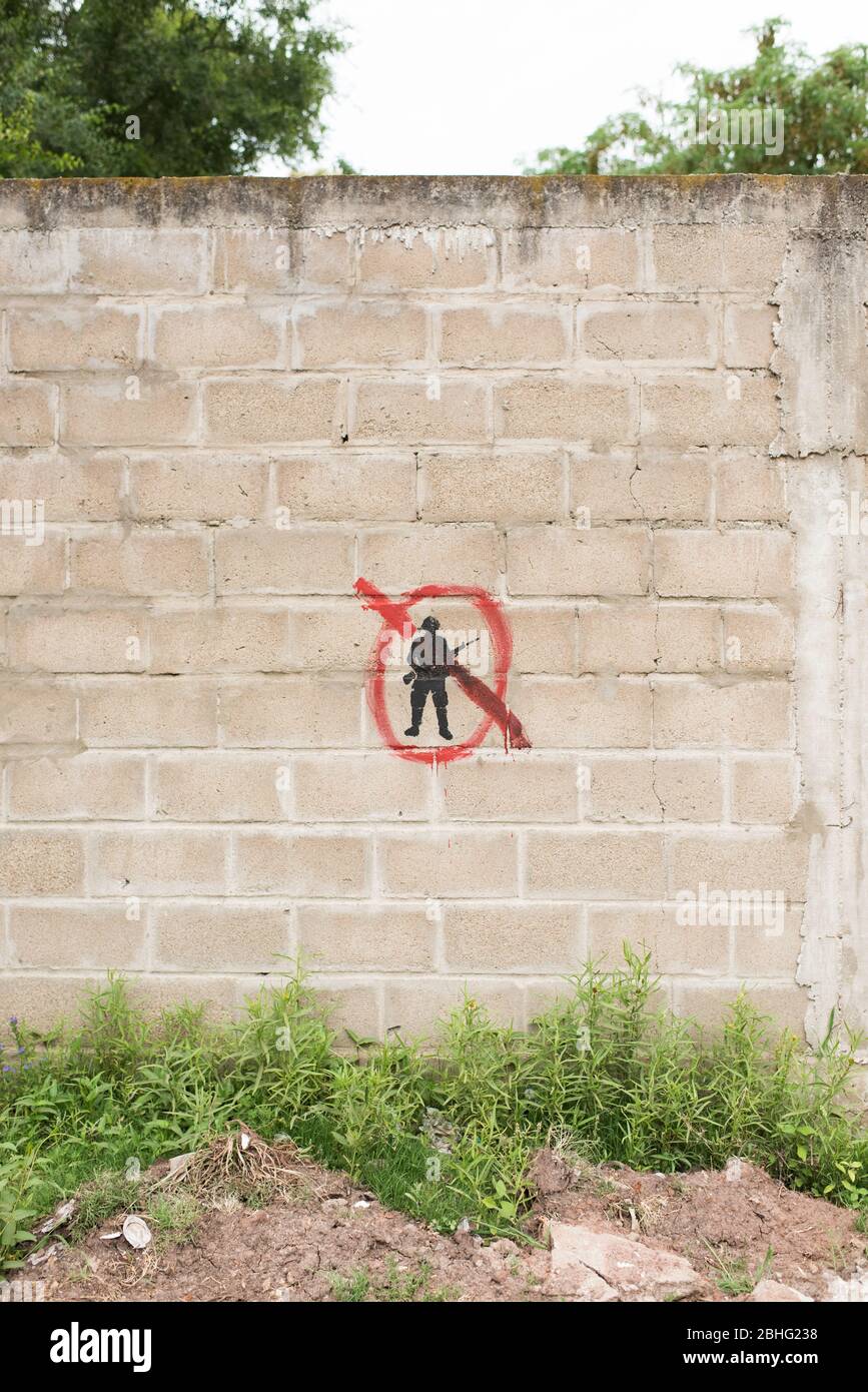 Carmelo, Colonia / Uruguay; 27. Dezember 2018: Betonsteinmauer mit einem bemalten Symbol: Eine schwarze militärische Silhouette mit roten durchgestrichen, Zeichen des Antikriegs Stockfoto