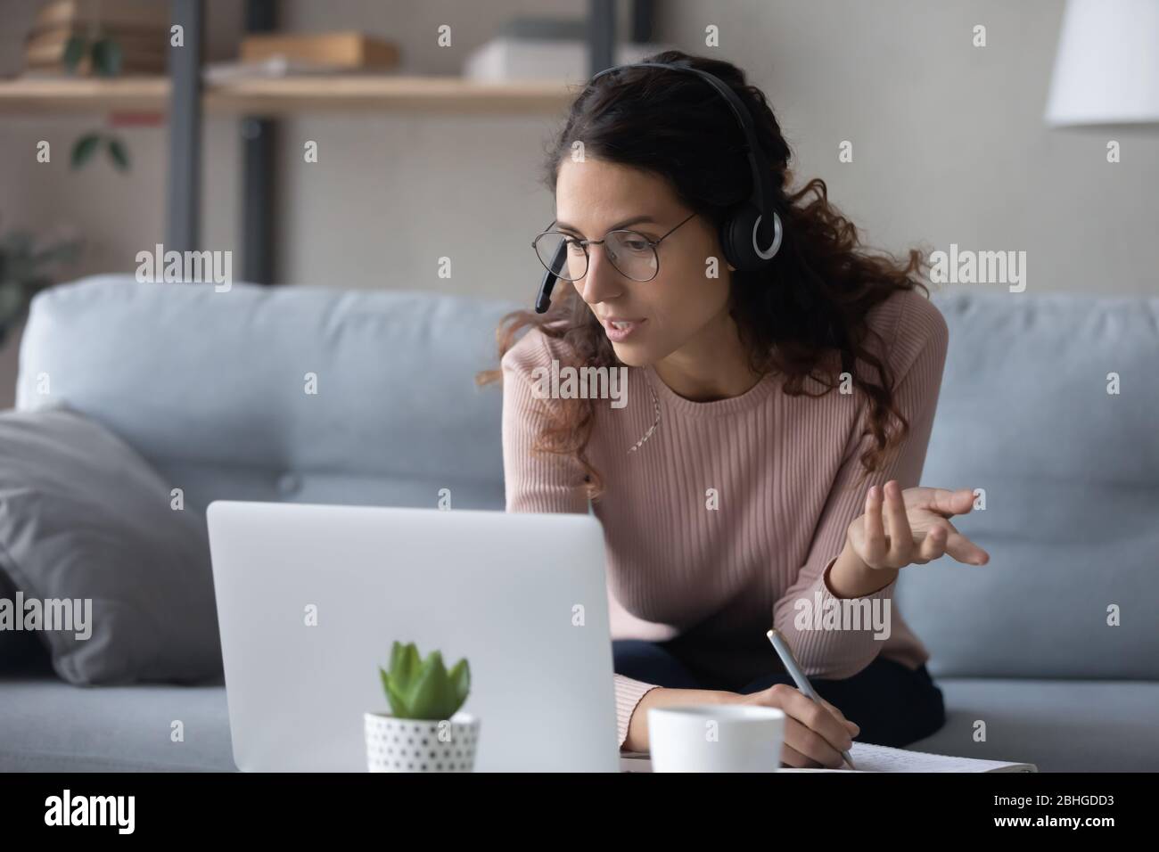 Fokussierte Millennial weibliche Studentin beobachten Online-Bildungs-Webinar, Notizen schreiben. Stockfoto