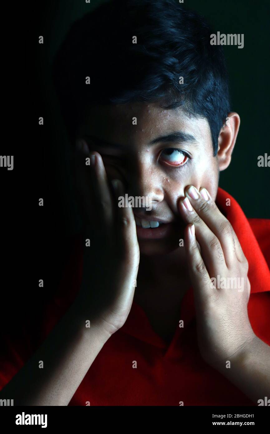 Porträt eines verängstigten asiatischen Jungen vor schwarzem Hintergrund. Ein indischer melancholischer Junge denkt. Traurigkeit Ausdruck eines asiatischen Jungen erschrocken Stockfoto
