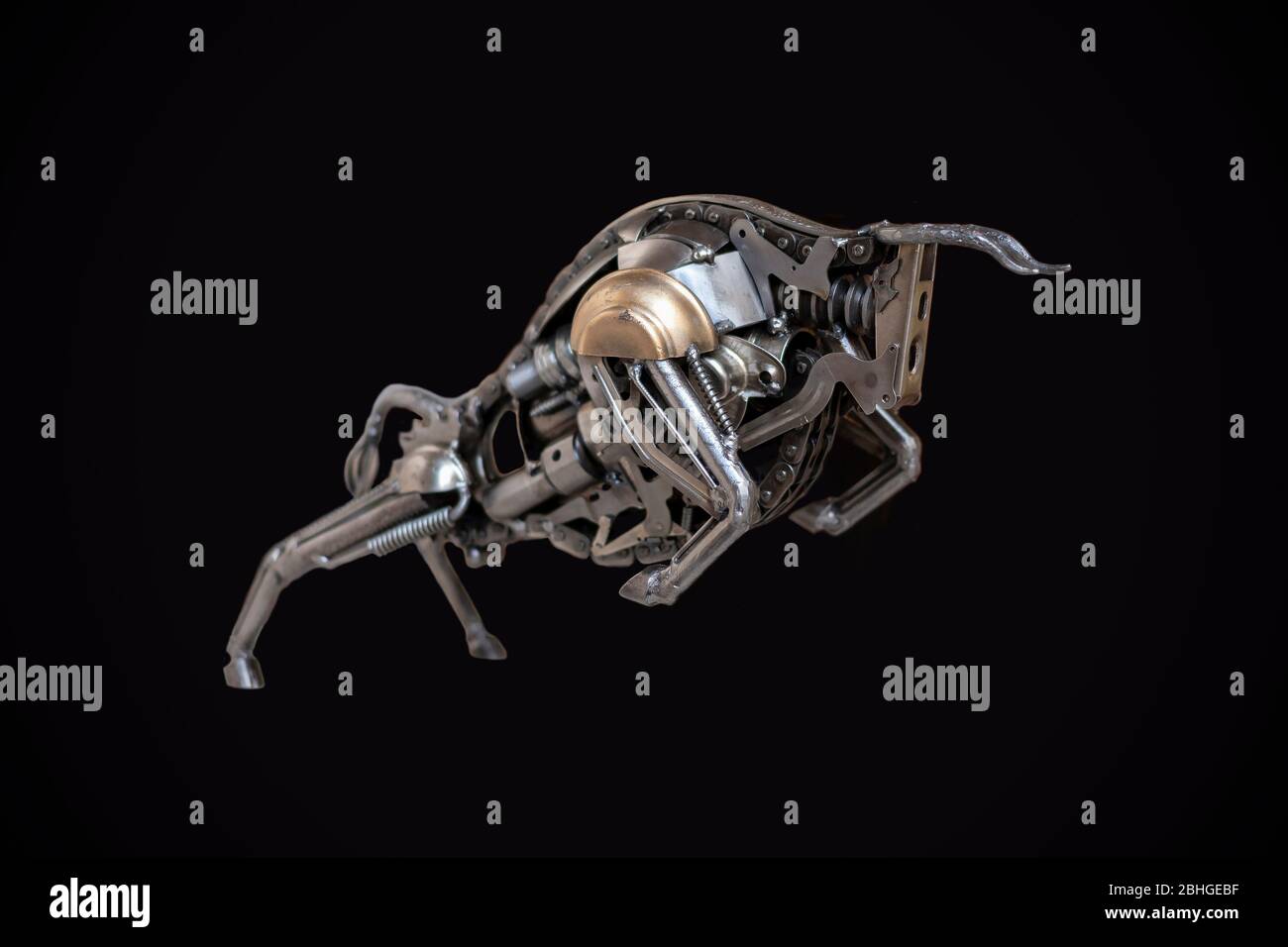 Eine aufladendes Stier Figur aus Schrauben und Federn auf schwarzem  Hintergrund isoliert Stockfotografie - Alamy