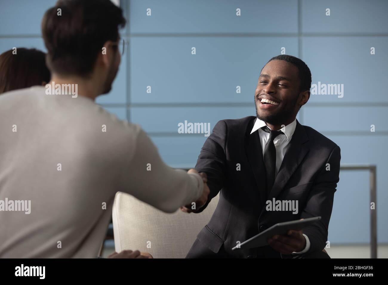 Gut aussehend afroamerikanischen Geschäftsmann im Anzug schütteln Hände mit Mann. Stockfoto
