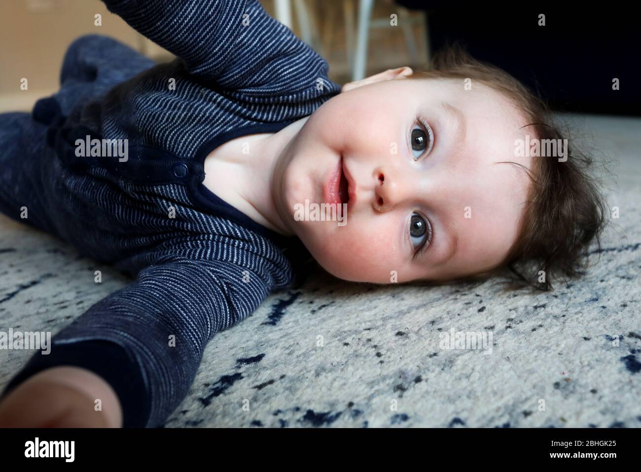 Schöner Junge, der während der Coronavirus Covid-19 Pandemie 2020 auf dem Boden spielt. Chichester, West Sussex, Großbritannien. Stockfoto