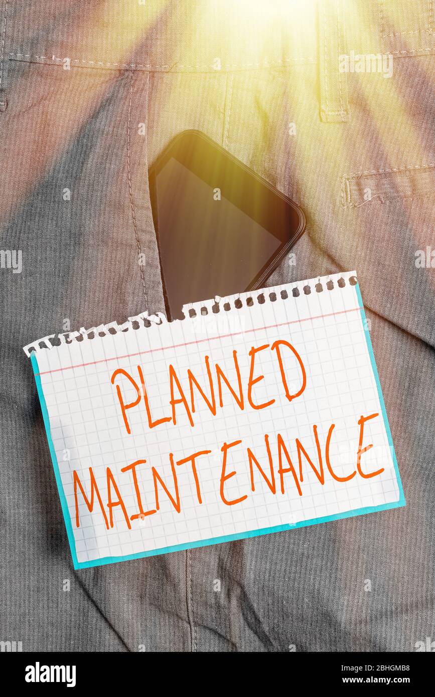 Schreiben einer Notiz mit der geplanten Wartung. Business-Konzept für Check-ups auf einer regelmäßigen Basis geplant werden Smartphone-Gerät in Hosen fro Stockfoto