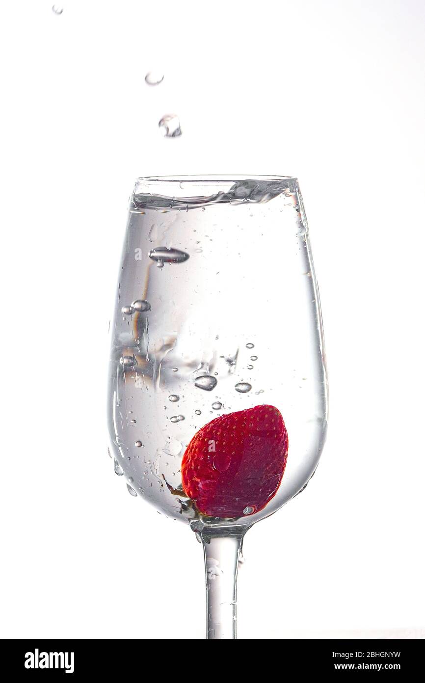 Erdbeere in einem Weinglas mit Wasser gefüllt. Stockfoto