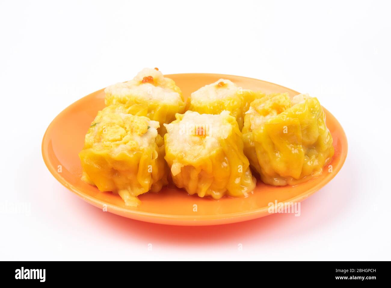 SIU Mai - Chinesische gedünstete Schweinefleischknödel auf Teller isoliert auf weißem Hintergrund. Stockfoto