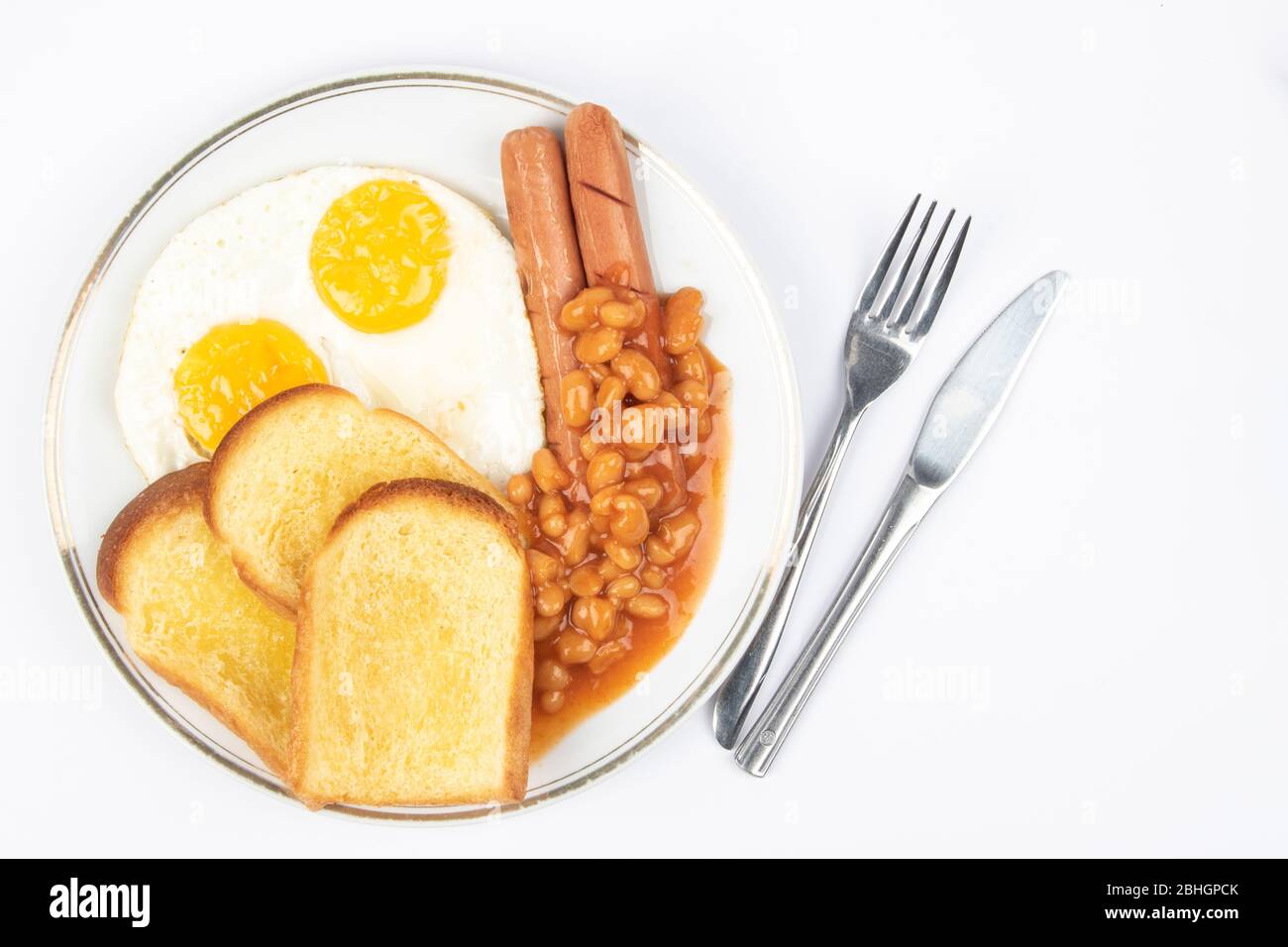 Englisches Frühstück mit Spiegeleiern, Würstchen, Bohnen und Toast auf weißem Hintergrund. Stockfoto