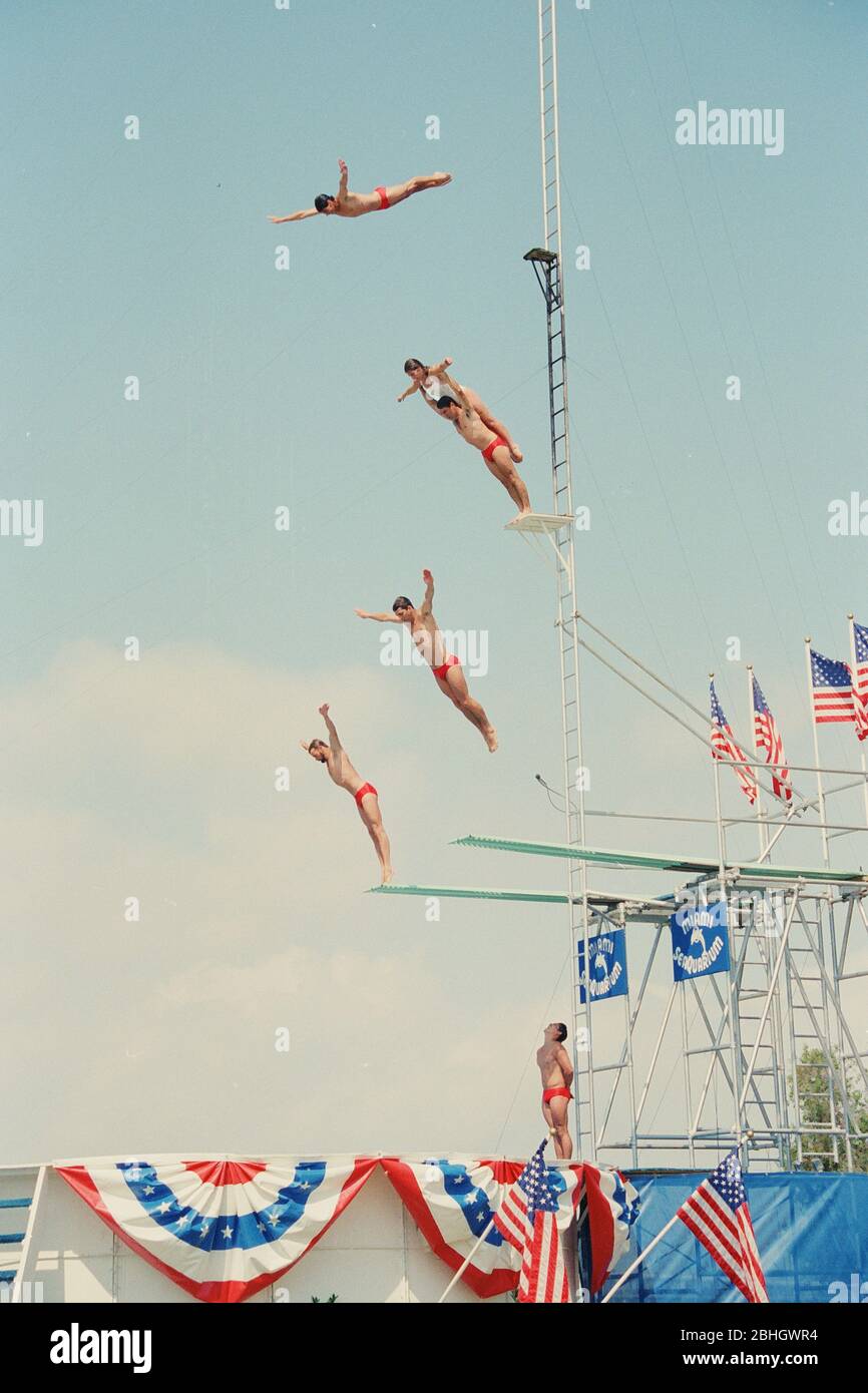 Springboard Taucher springen aus großen Höhen in ein kleines Becken während einer Performance im Miami Seaquarium in den 1980er Jahren, Florida, USA Stockfoto