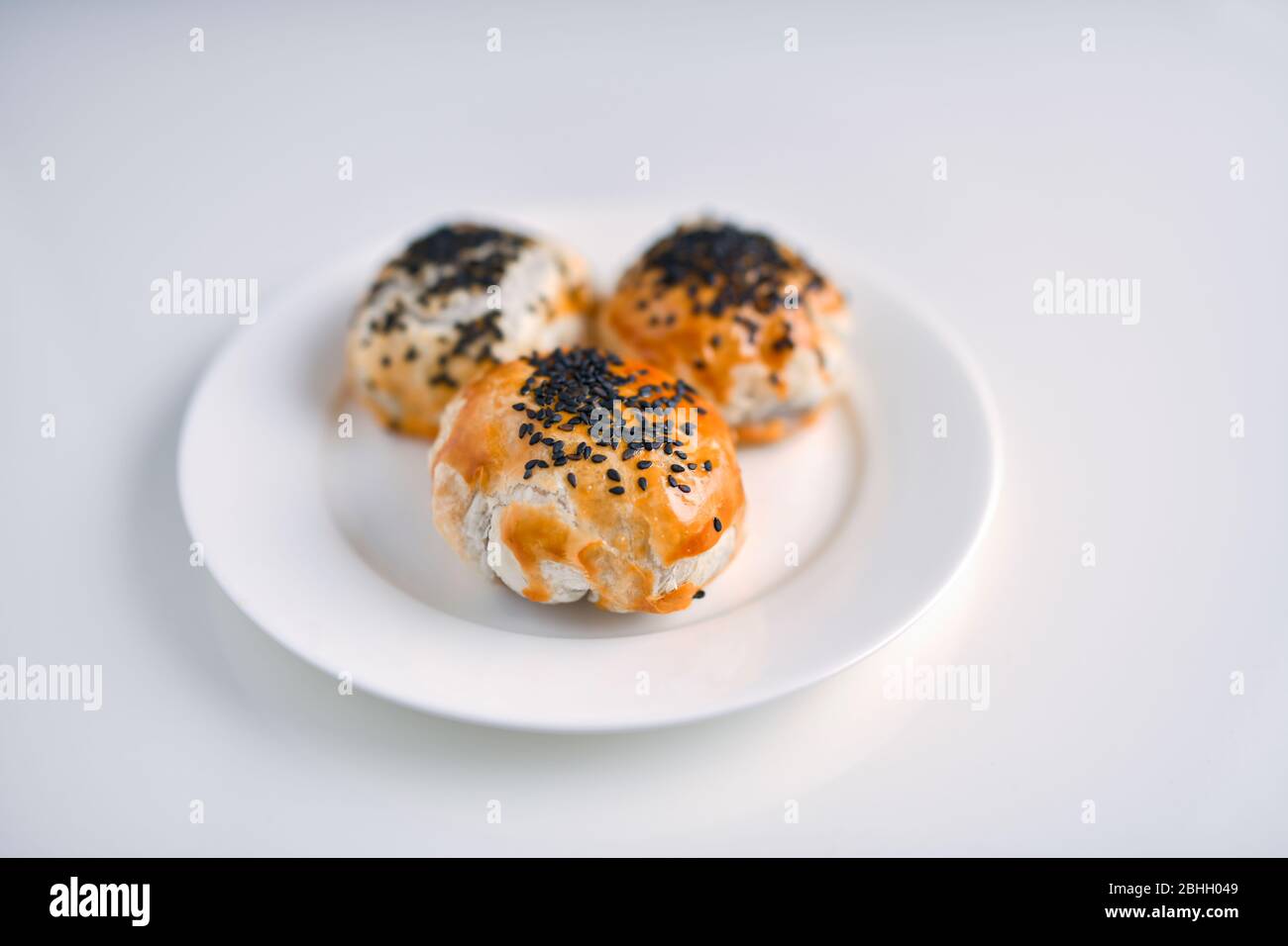 Chinesische rote Bohnenpaste Kuchen auf Keramikplatte, isoliert auf weißem Hintergrund Stockfoto