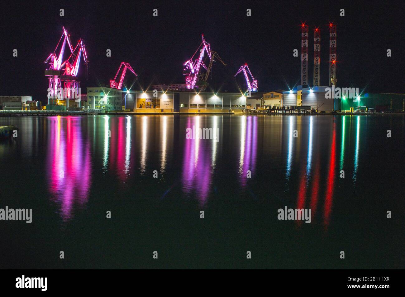 Lighting Giants - farbenfrohe beleuchtete Kräne bei Nacht in Pula, Istrien Halbinsel in Kroatien Stockfoto