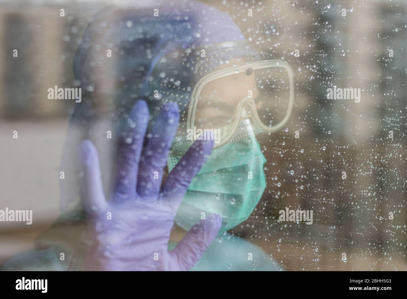 Foto der Krankenschwester im Krankenhaus, mit Schutzausrüstung für Coronavirus, isoliert aufgrund der Quarantäne. Regnerischer Tag. Stockfoto