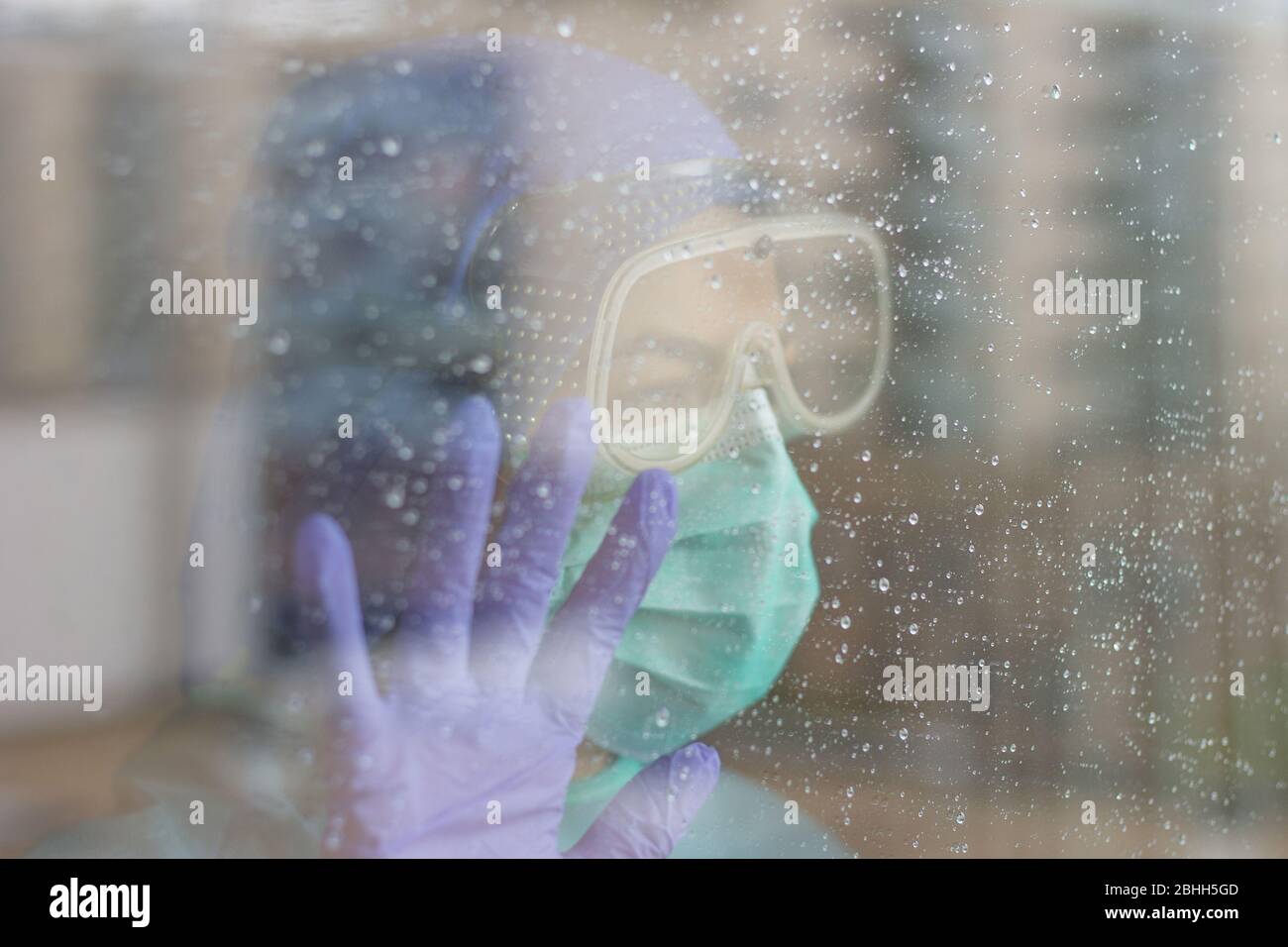 Foto der Krankenschwester im Krankenhaus, mit Schutzausrüstung für Coronavirus, isoliert aufgrund der Quarantäne. Regnerischer Tag. Stockfoto