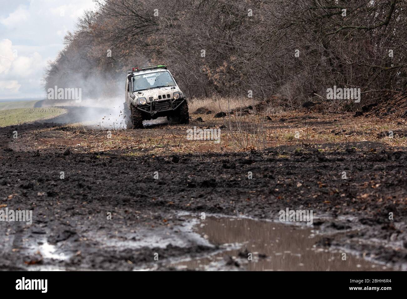 Das Geländewagen fährt auf einer schlechten, schmutzigen Straße. Stockfoto