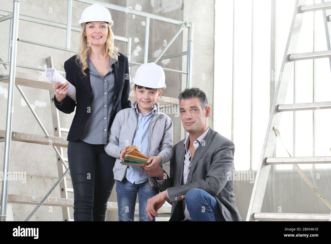 Ein paar Architekten und Bauingenieure wählen zusammen mit ihrem Sohn die Muster für die Planung des Projekts aus. Haus kaufen und Gebäude Ziel Konzept Stockfoto