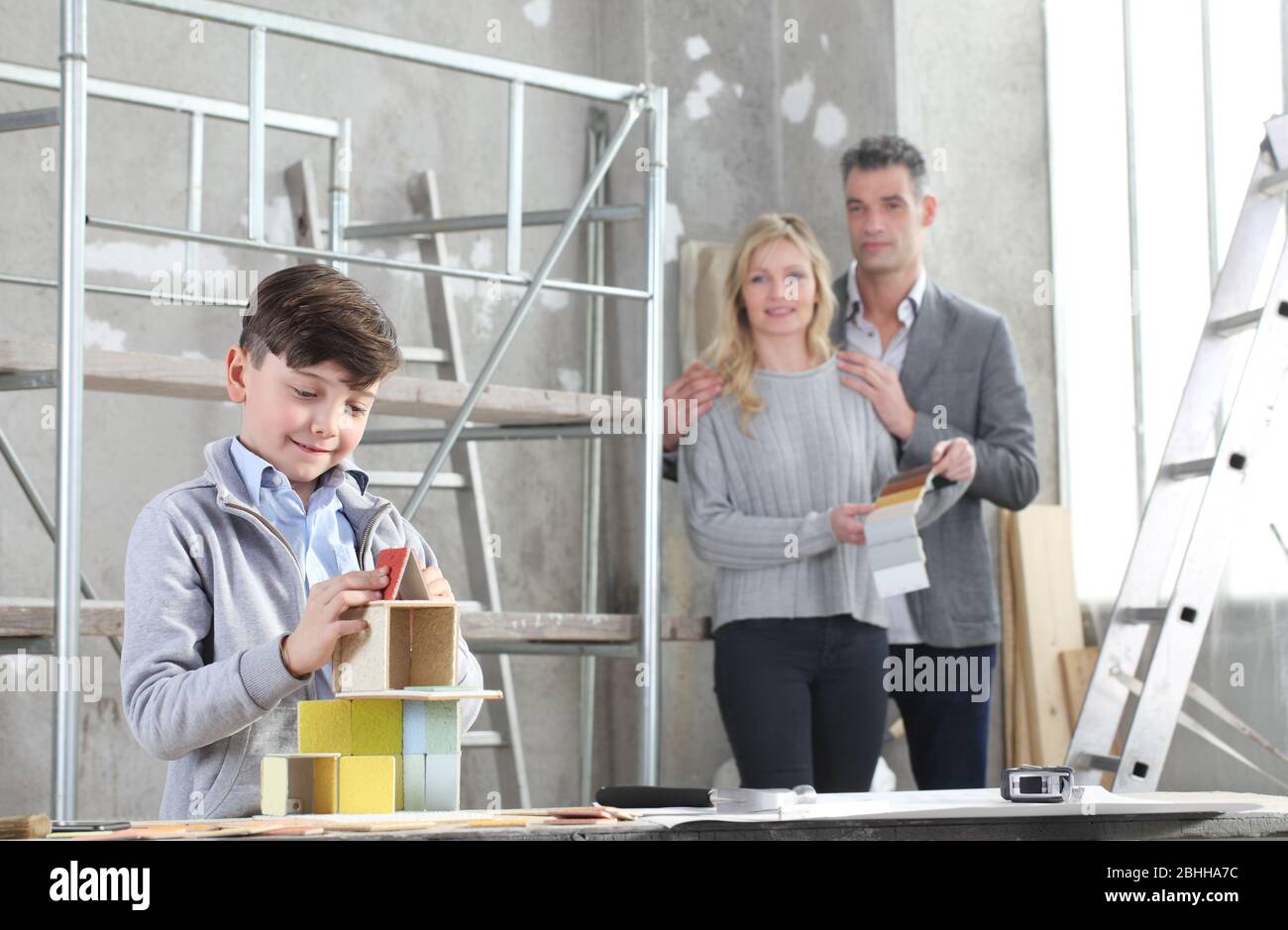 Glückliche Kinder und seine Familie spielen beim Bau eines Hauses mit Baumodellen auf der Baustelle. Haus kaufen und Gebäude Ziel Konzept Stockfoto