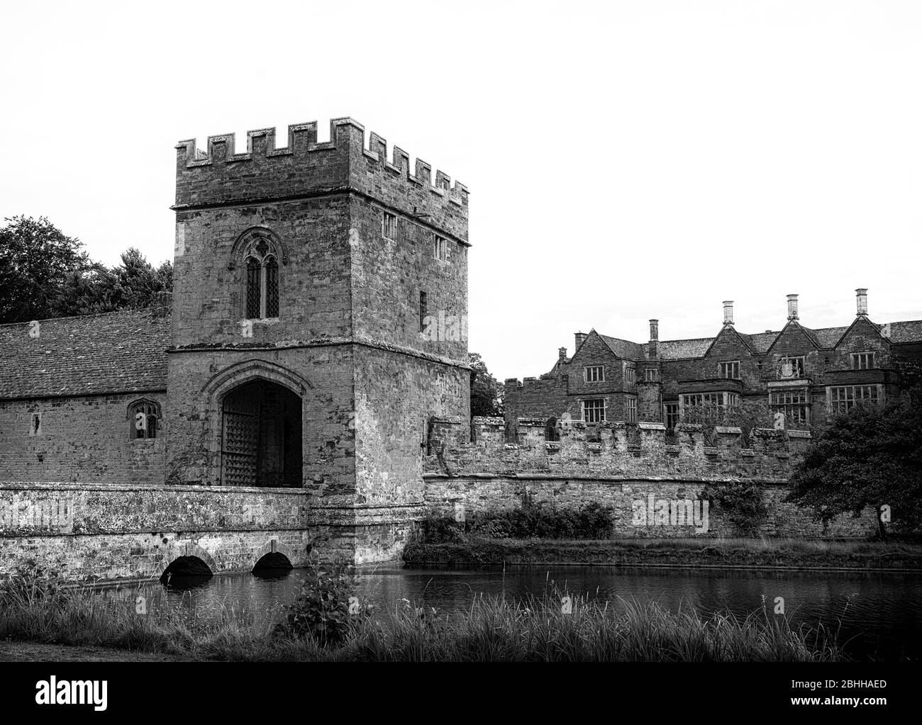 Broughton Castle in Oxfordshire, in schwarz und weiß von der anderen Seite des Grabens. Stockfoto