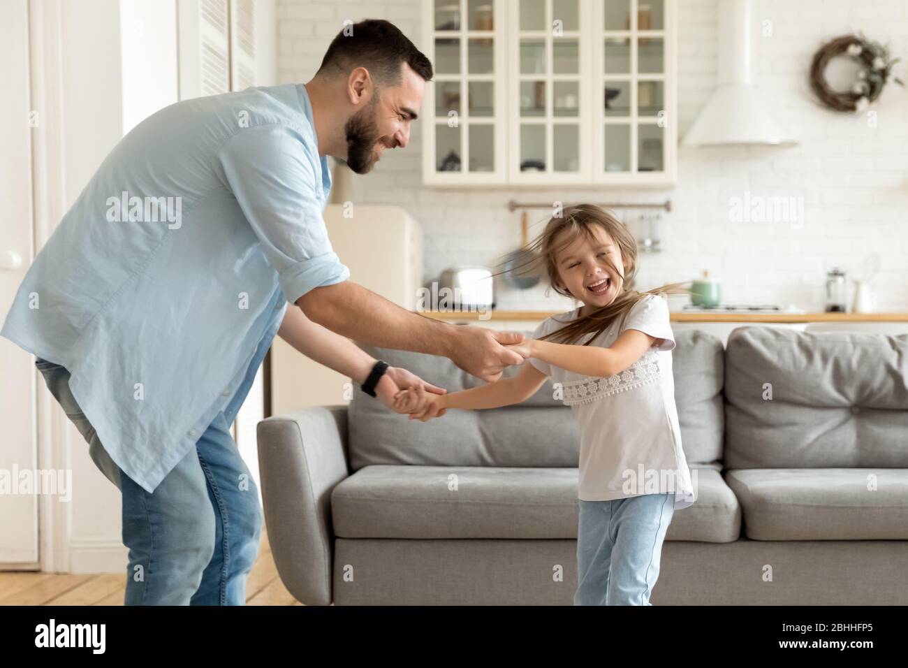 Lächelnder Single Papa, der lustige Familienaktivitäten mit lachender Tochter genießt. Stockfoto