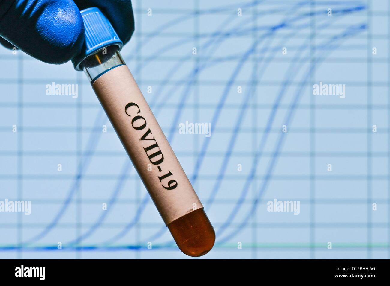 Real-Time PCR-Tests mit COVID-19. Ein Reagenzglas mit einer Probe auf dem Hintergrund von Amplifikationskurven. Stockfoto