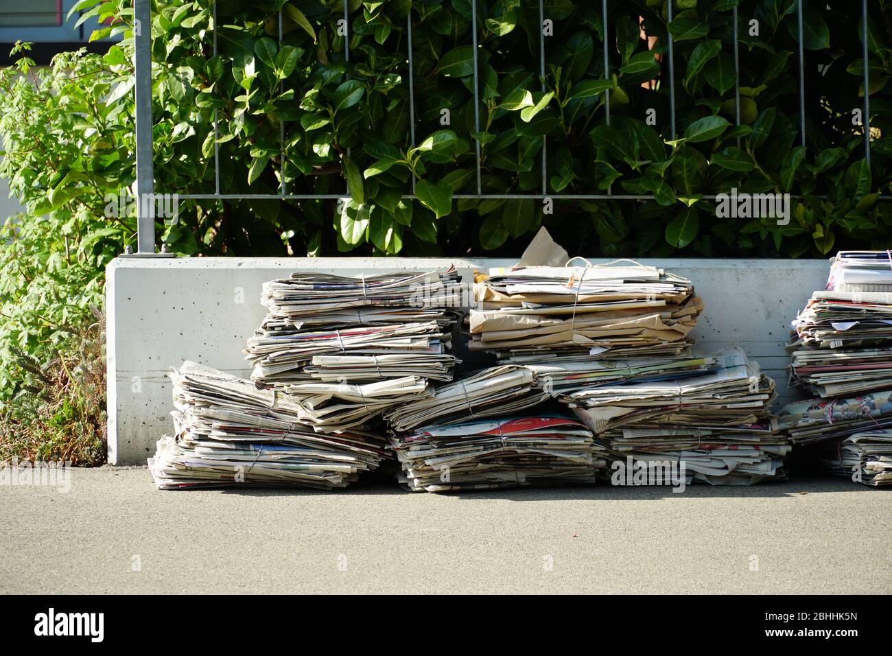 Mülltrennung in der Schweiz. Altes Papier in Paketen gebündelt und auf die Straße gestellt, um gesammelt zu werden. Stockfoto