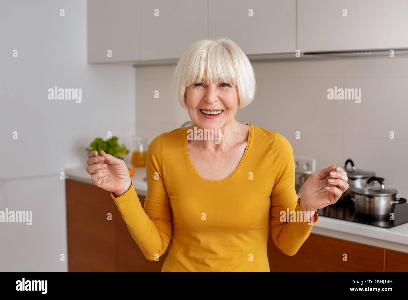 Ruhestand. Ältere Frau in der Küche lächelnd aufgeregt Stockfoto
