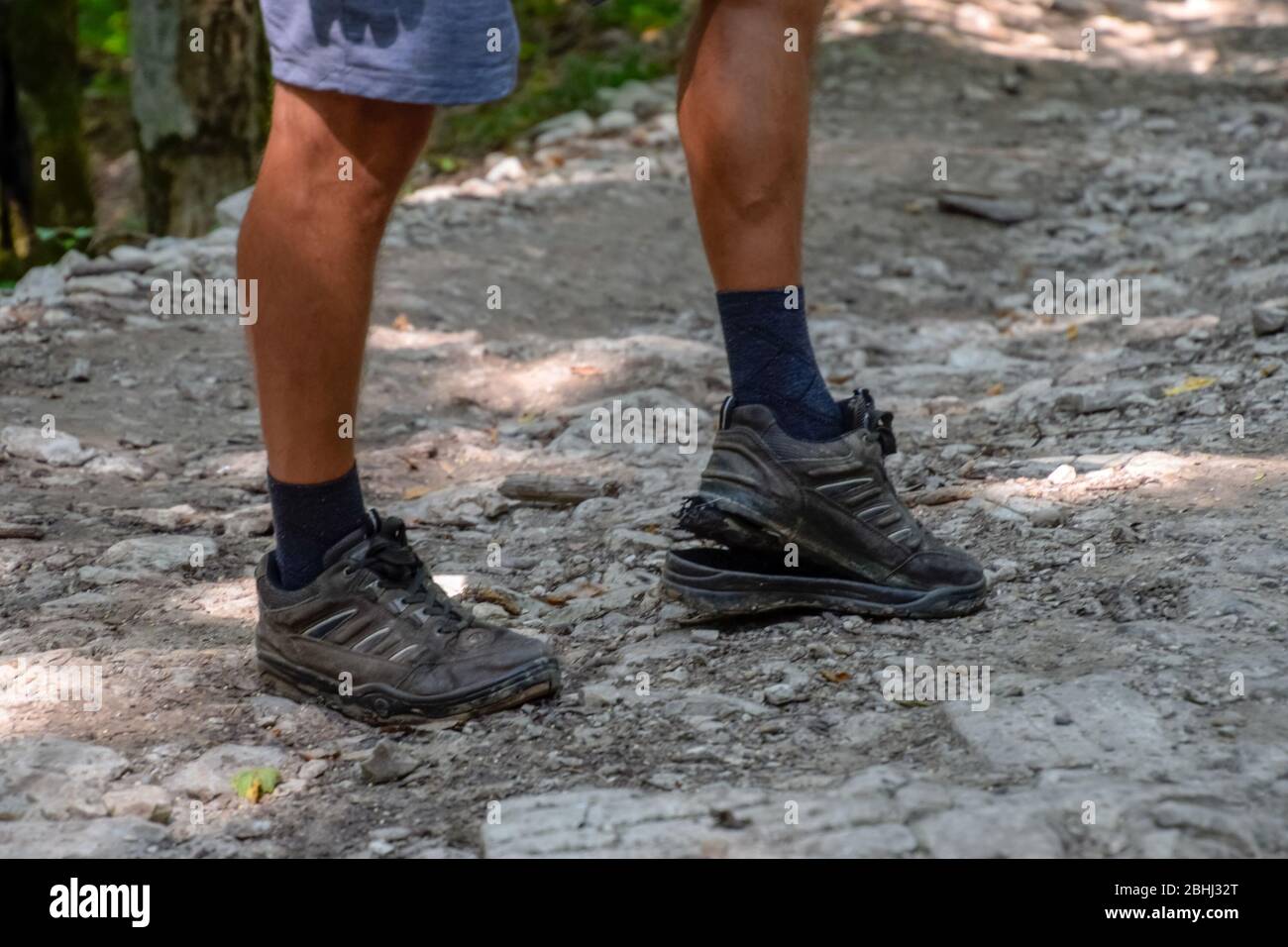 Die abgelöste Sohle auf den Turnschuhen des Touristen. Sie brachen ihre Stiefel im Wald. Stockfoto