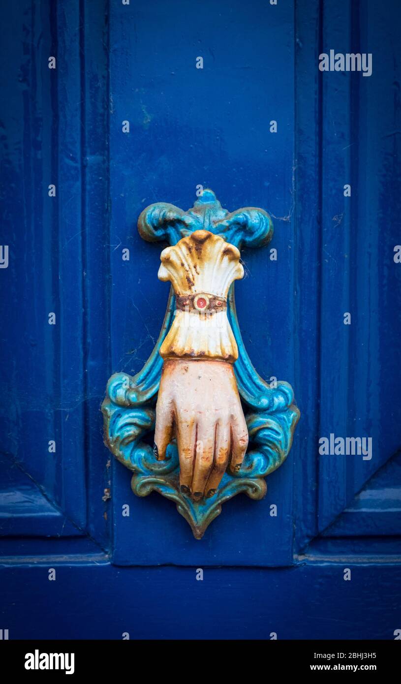 Türklopfer in Form einer Hand auf einer blauen Tür Stockfoto
