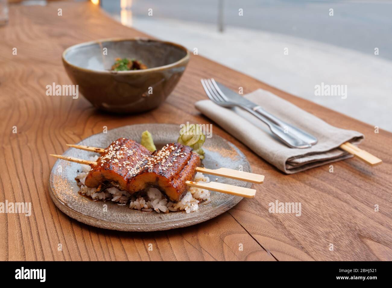 Gebratener Unagi-Aal mit Grillsoße und Reis in Tonteller Stockfoto