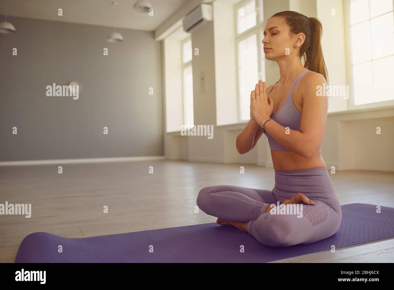 Mädchen Frau Yoga in Lotusposition entspannt am Morgen bei Sonnenaufgang im Zimmer. . Stockfoto