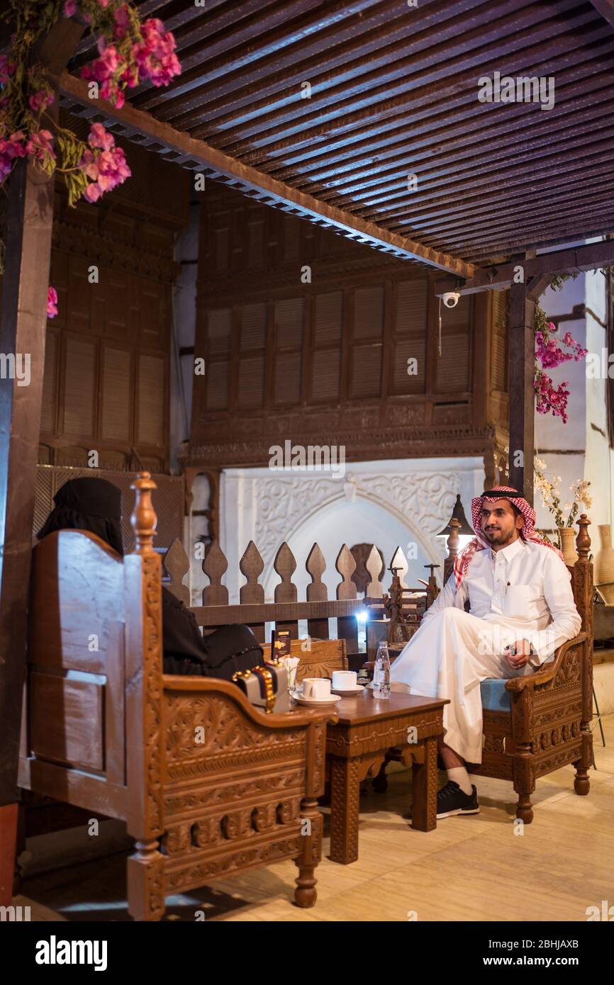 Jeddah / Saudi Arabien - 16. Januar 2020: Saudi-arabisches muslimisches Paar in traditioneller Kleidung und in einem schönen Restaurant, um Kaffee zu trinken Stockfoto
