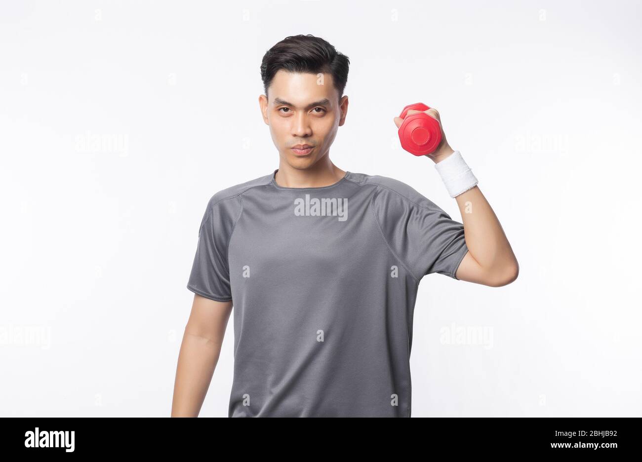 Junge asiatische Mann in Sport-Outfits mit Hanteln trainieren und schauen auf Kamera isoliert auf weißem Hintergrund. Stockfoto
