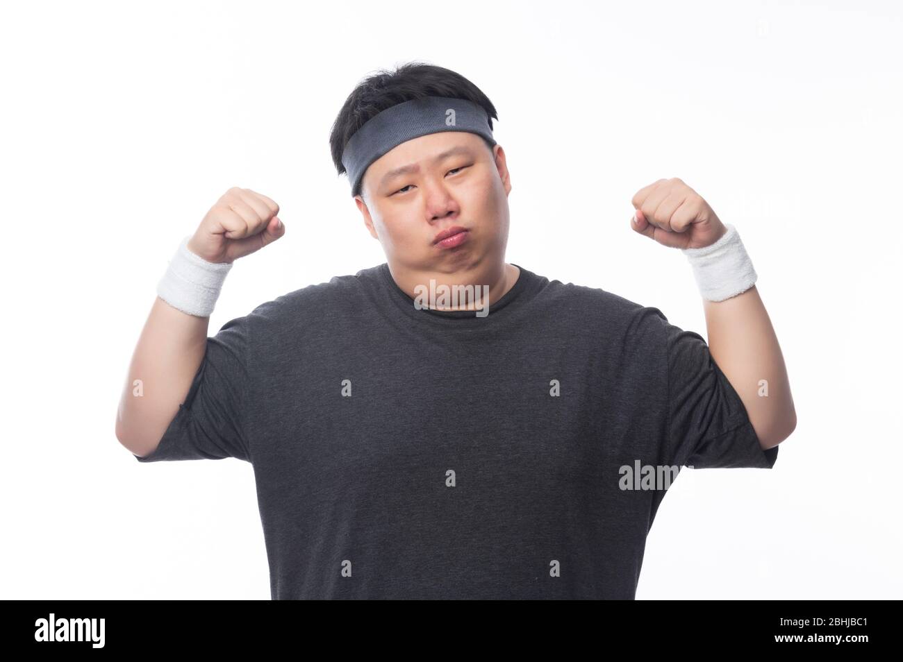 Asiatische Funny Fat man in Sport-Outfits zeigt Stärke und suchen Kamera isoliert auf weißem Hintergrund. Stockfoto