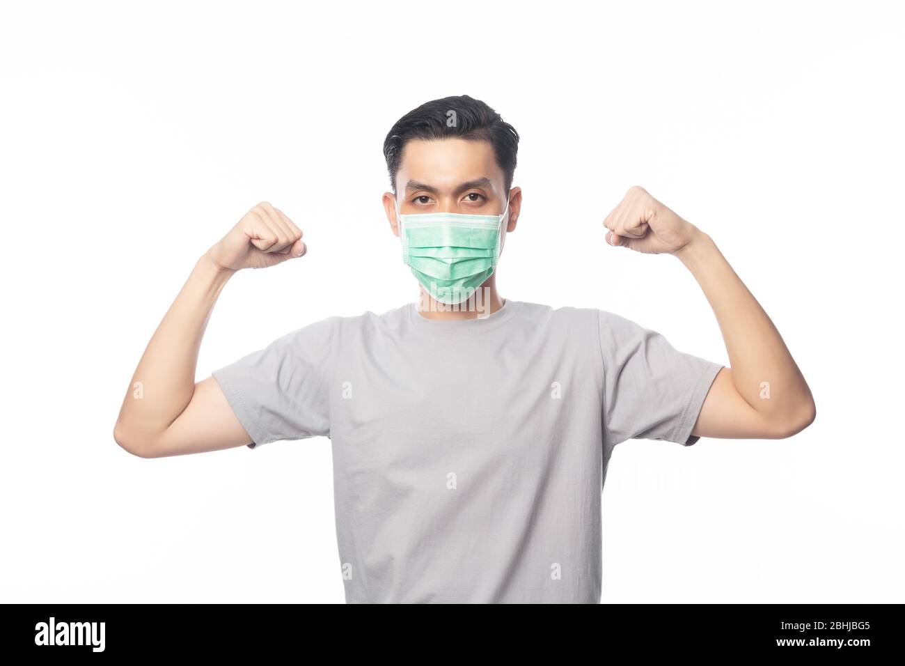 Junger Asian Mann in hygienischer Maske zeigt Stärke, um Infektionen zu verhindern, 2019-nCoV oder Coronavirus. Atemwegserkrankungen in der Luft, wie z. B. PM 2.5-Kämpfe Stockfoto