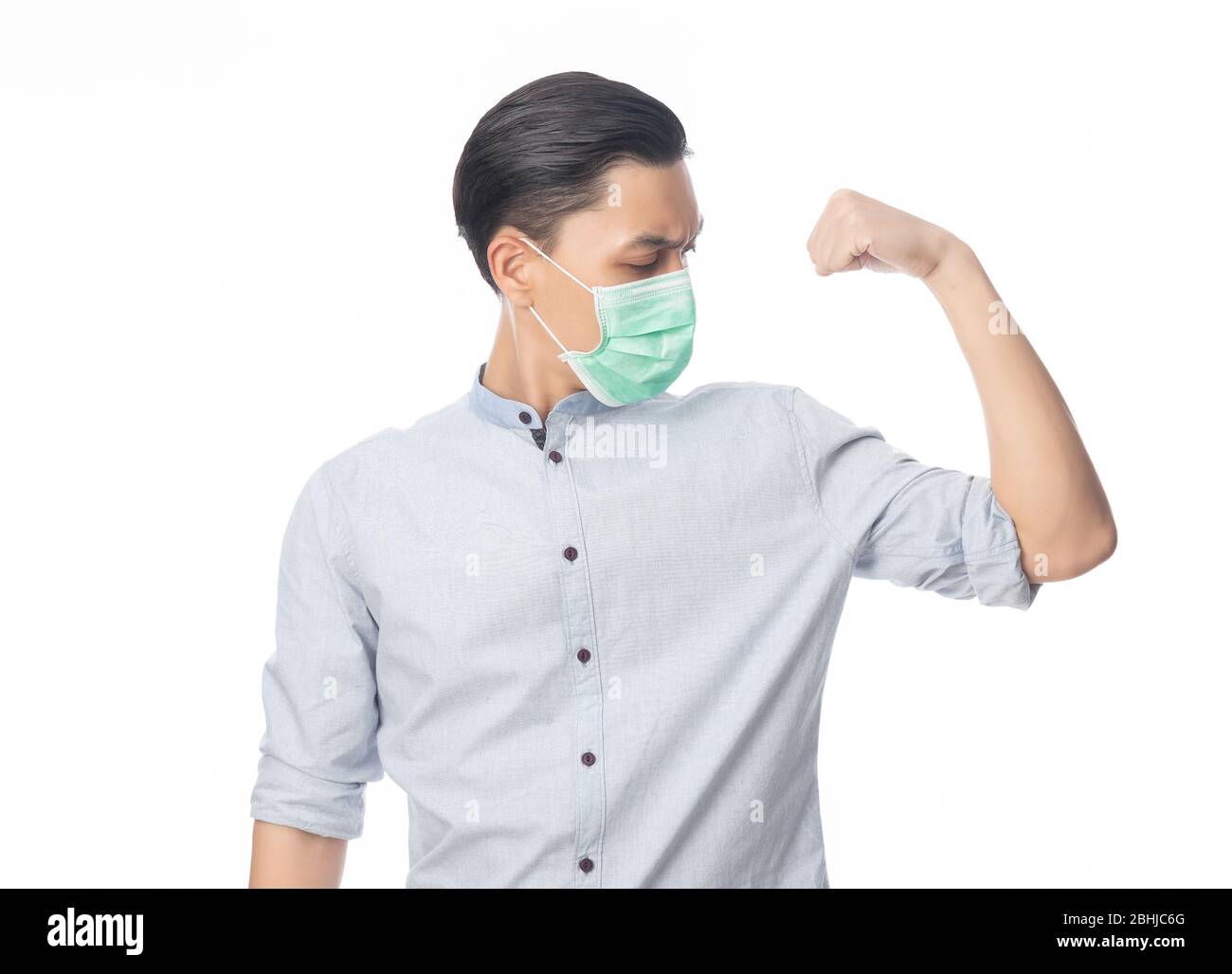 Junge asiatische Geschäftsmann in hygienischen Maske zeigt Stärke, um Infektionen zu verhindern, 2019-nCoV oder Coronavirus. Atemwegserkrankungen in der Luft, wie z. B. PM 2.5 Stockfoto