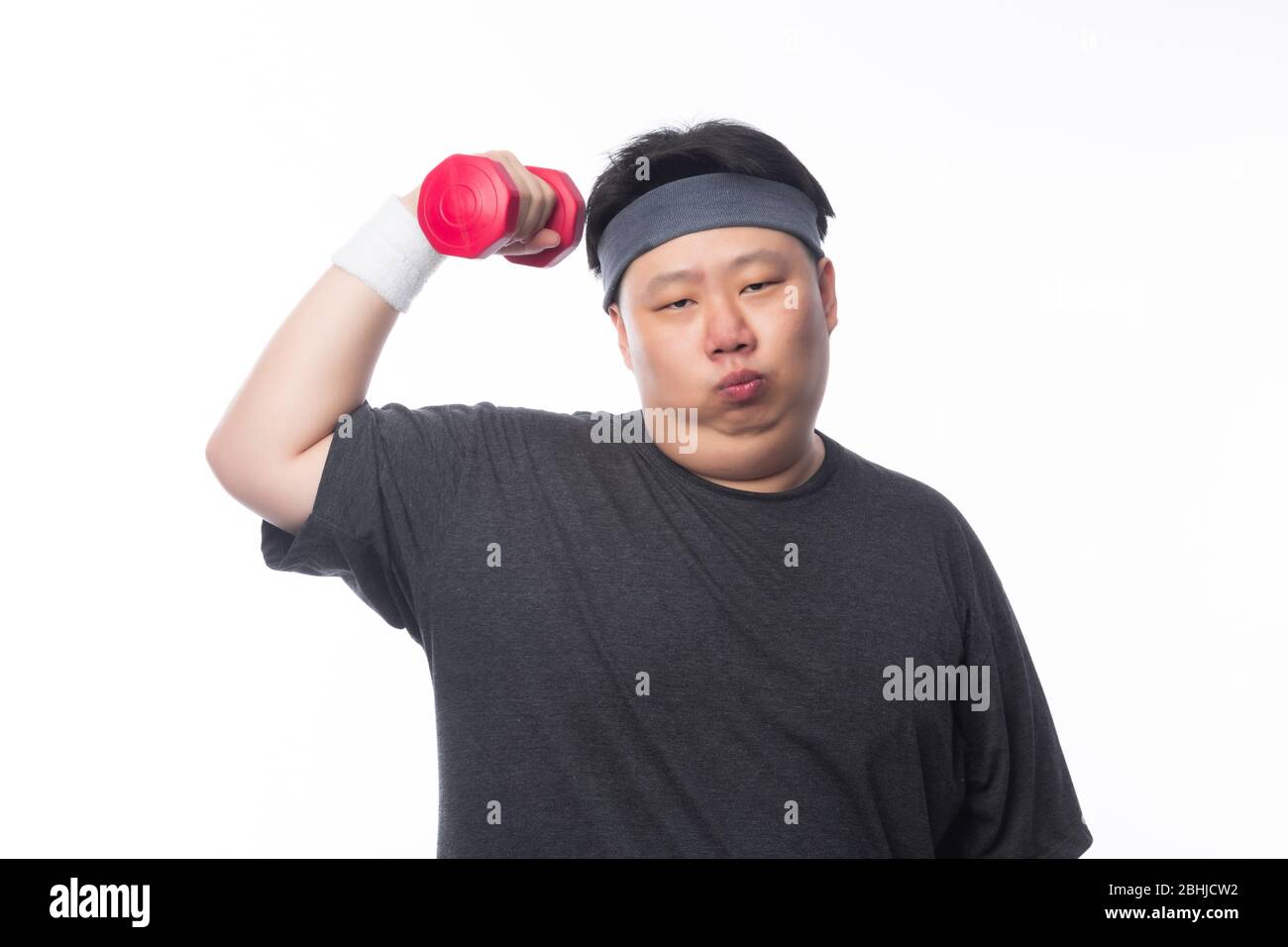 Asiatische lustige Fett Mann in Sport-Outfits mit Hantel trainieren und auf Kamera isoliert auf weißem Hintergrund suchen. Stockfoto