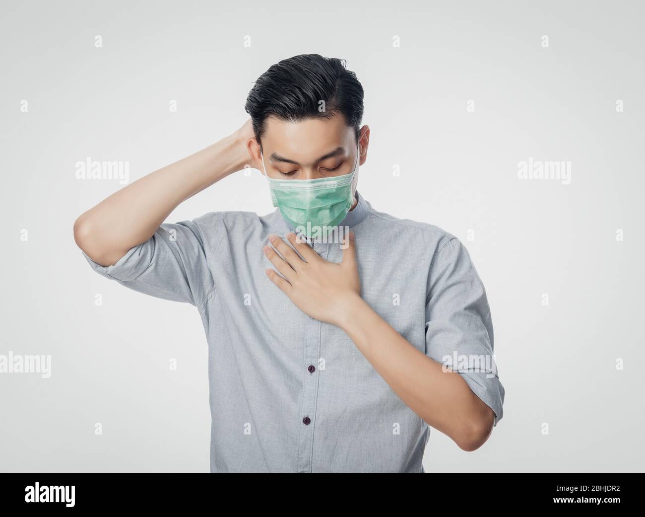 Junge asiatische Geschäftsmann in hygienischen Maske leiden Halsschmerzen und Grippe, 2019-nCoV oder Coronavirus. Atemwegserkrankungen in der Luft, z. B. PM 2.5 f Stockfoto