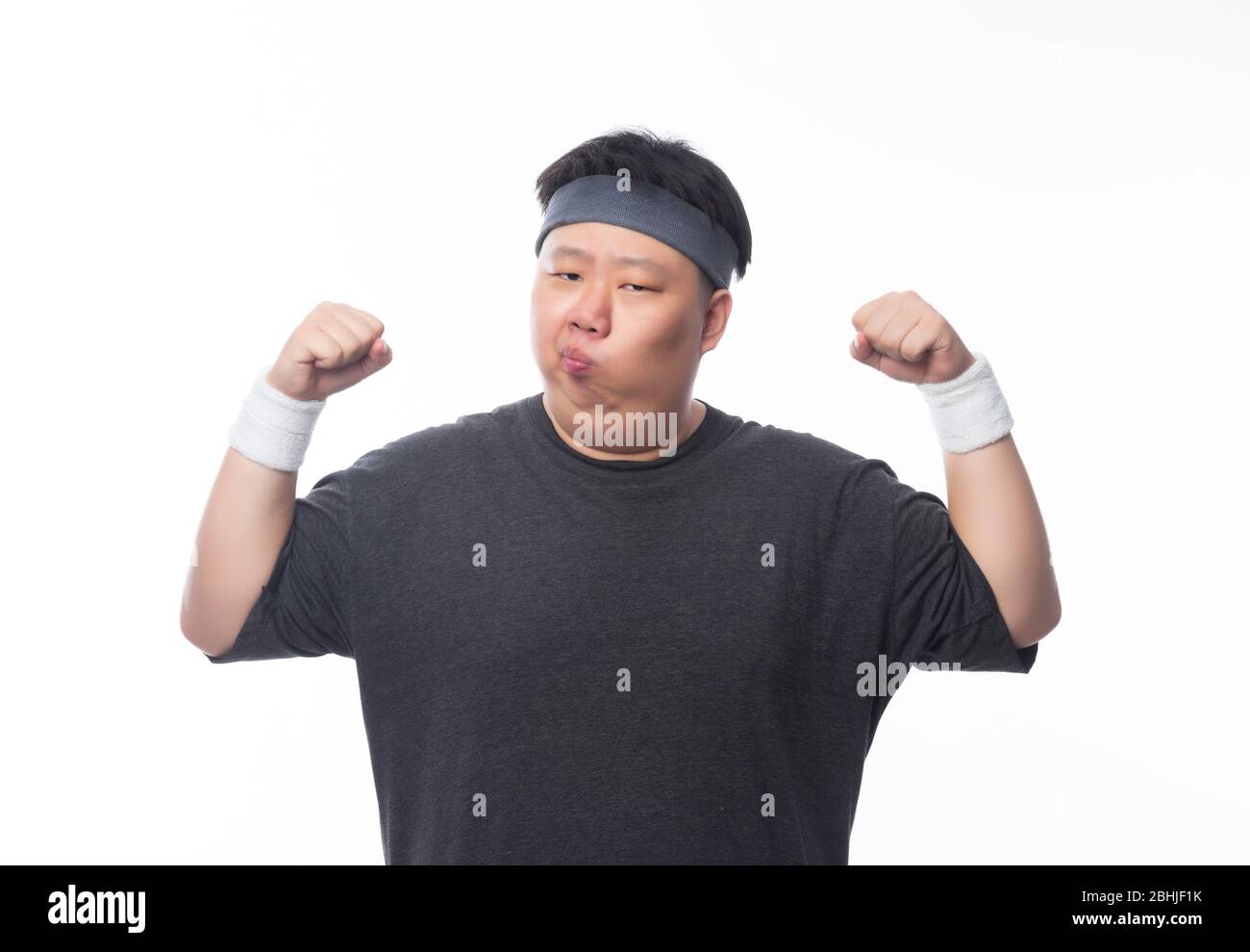 Asiatische lustige Fett Mann in Sport-Outfits zeigt Stärke und suchen Copyspace isoliert auf weißem Hintergrund. Stockfoto
