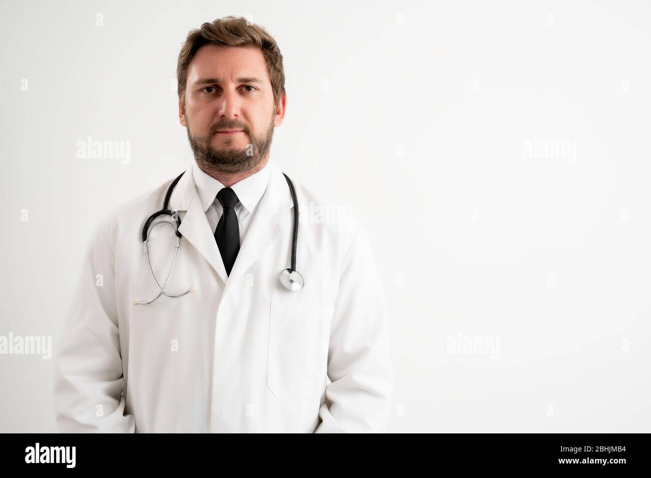 Porträt des männlichen Arztes mit Stethoskop in medizinischer Uniform posiert auf einem weißen isolierten Hintergrund Stockfoto