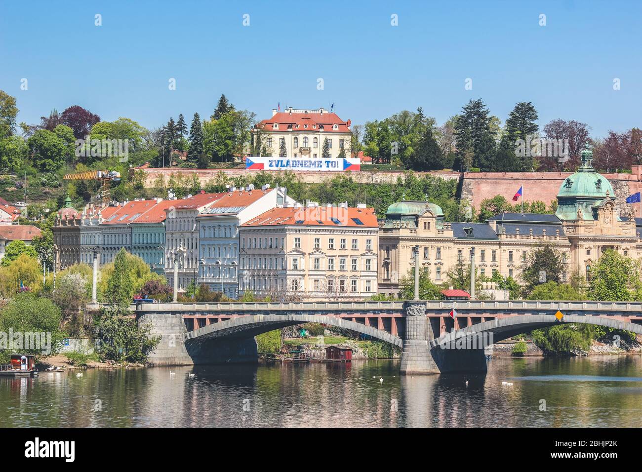 Kramars Villa in Prag, Tschechische Republik. Der Sitz des tschechischen Ministerpräsidenten auf dem Hügel mit tschechischen Flaggen und Motivationszeichen während der Coronavirus-Pandemie. ÜBERSETZUNG des Zeichens: Wir können es schaffen. Stockfoto