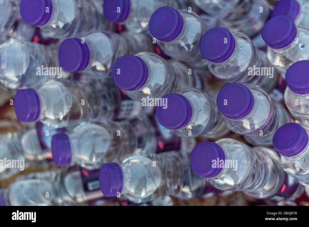 Ein Nahaufnahme-Foto einer Gruppe von vielen Kunststoff-Mineralwasserflaschen, gefüllt mit frischem, klarem, sauberem und gesundem Erfrischungsgetränk Stockfoto