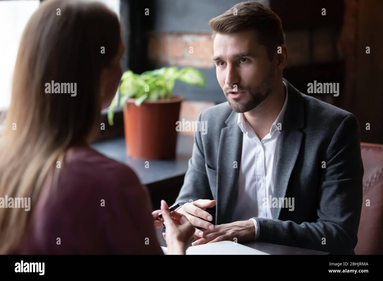 Verschiedene Geschäftsleute treffen sich im Café, um über Zusammenarbeit zu diskutieren Stockfoto