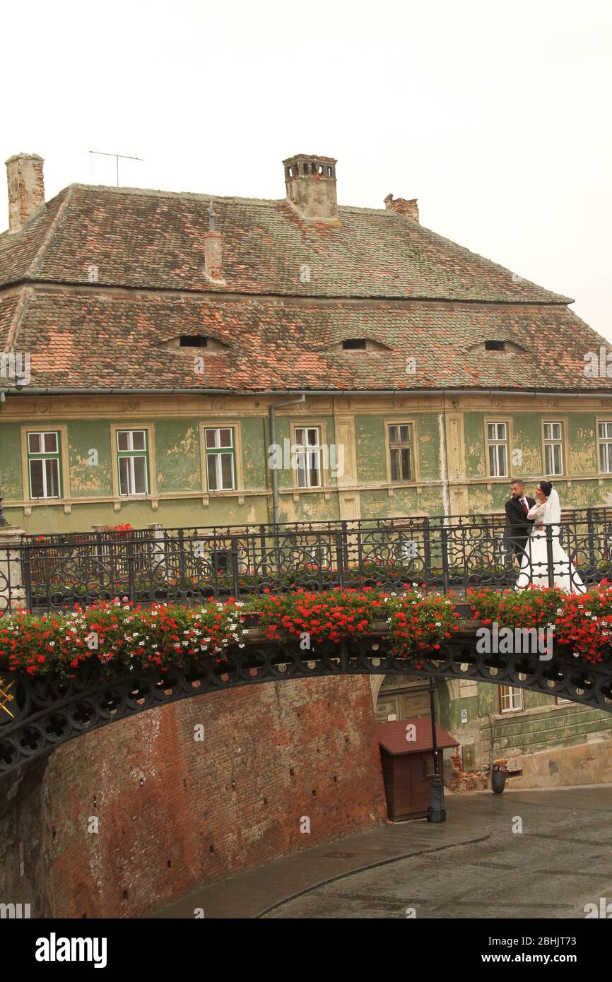 Sibiu, Rumänien. Frisch vermählte bei einer Fotosession auf der Brücke der Lügen in der Altstadt. Stockfoto