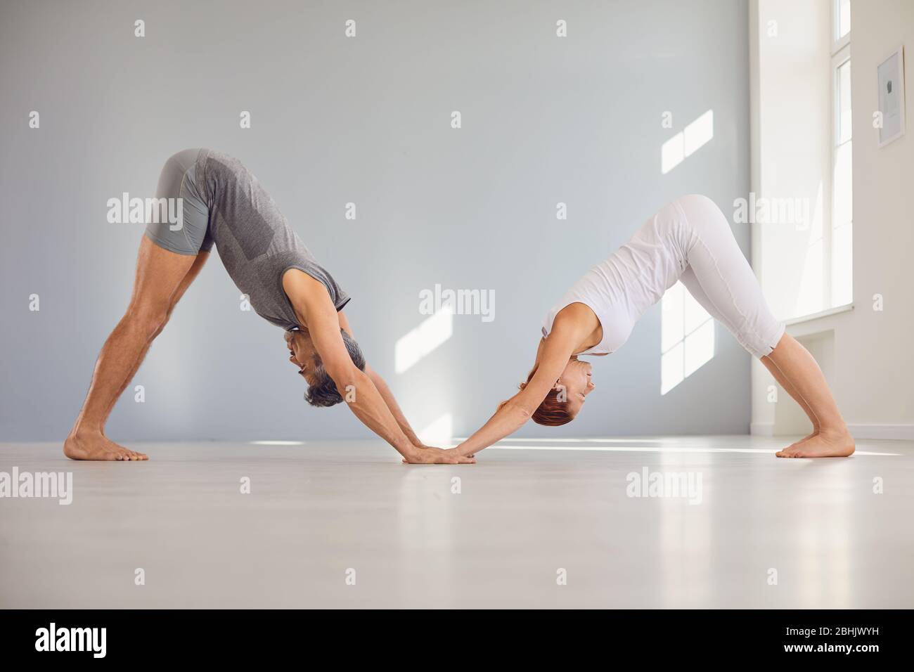 Yoga-Pose für Paare auf dem Boden in einer Studioklasse. Stockfoto