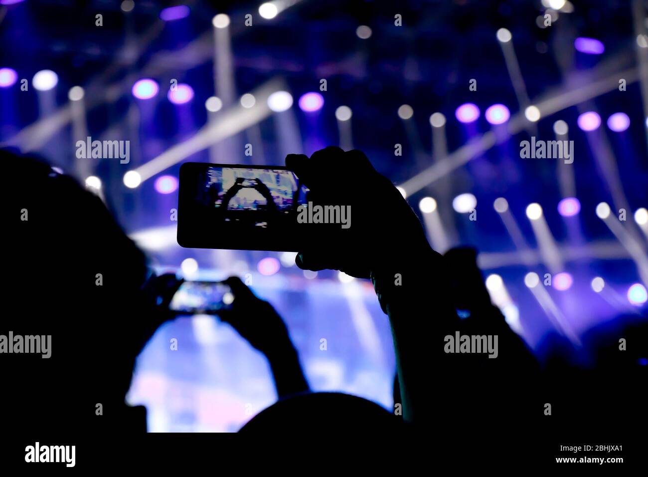 Das Sammeln von digitalem Speicher verliert die Fähigkeit, anwesend zu sein, Silhouette von Menschen Hände schießen das Konzert mit Smartphones Stockfoto
