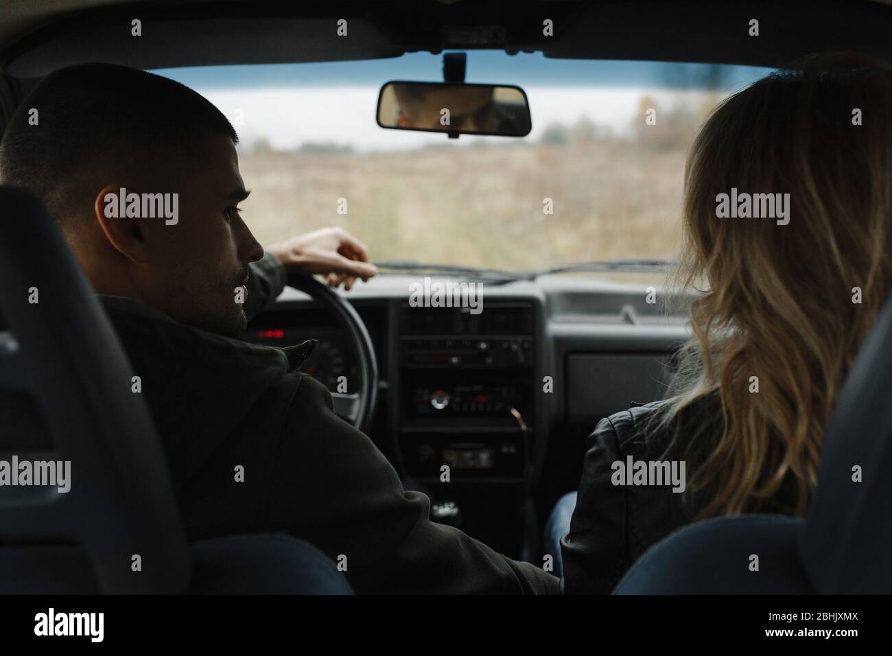 Mann, der im Auto sitzt und seine Frau anschaut Stockfoto