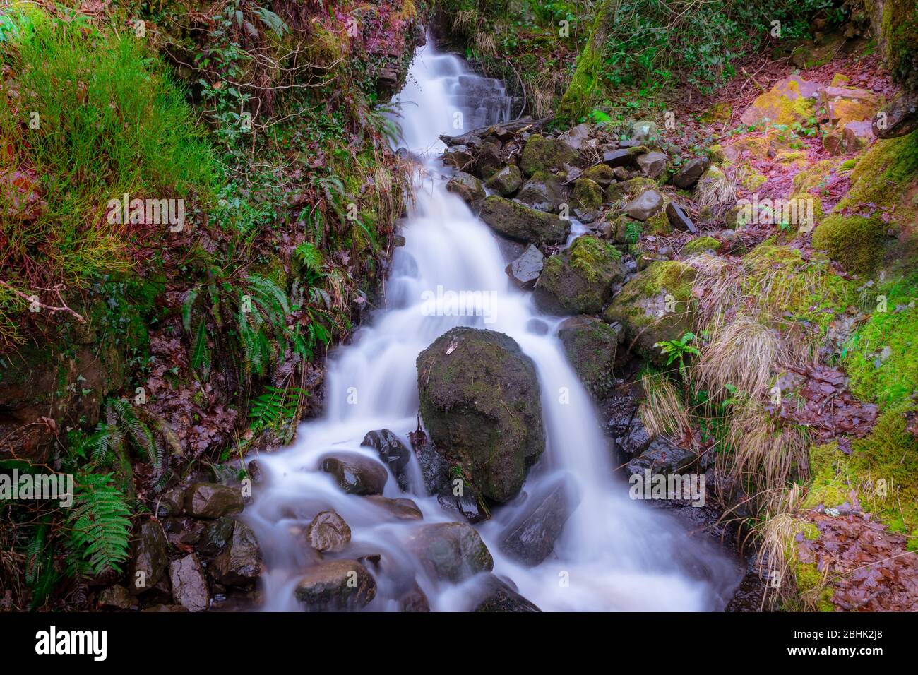 Ein Mini-Wasserfall auf dem Elidir Trail; Eintritt in das Märchenreich am Ufer des Nedd. Lange Belichtung Stockfoto